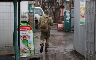 epa09750546 Ukrainian serviceman leaves a street market in the small city of New York, not far from a front line near pro-Russian militants controlled city of Donetsk, Ukraine, 12 February 2022. Since 2014 locals adapted to live close to the front line what bring some restrictions to their life. The settlement first appeared on maps in 1846 under its original name New York. In 1951 was renamed to Novgorodskoye due to the worsening of relations of USSR with USA was. In July of 2021 Ukrainian Parliament returned it's old name New York.  EPA/STANISLAV KOZLIUK