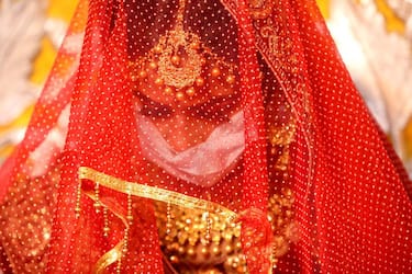 epa08486559 Bride Angoori wears a face mask during her wedding ritual in Bhopal, India, 15 June 2020. According to state government guidelines, a maximum of 25 people from groom and bride side, a total of 50, are allowed to attend the wedding ceremonies due to the coronavirus pandemic and related restrictions.  EPA/SANJEEV GUPTA