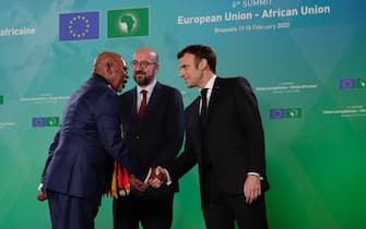 epa09770135 Ugandan Foreign Minister Jeje Odongo (L) is welcomed by European Council President Charles Michel (C) and French President Emmanuel Macron (R), during the sixth European Union - African Union summit in Brussels, Belgium, 18 February 2022. The leaders of the African Union (AU) join EU leaders for a two-day summit in Brussels.  Ahead of the summit, EU heads of state or government will gather for an informal meeting of the members of the European Council to discuss the state of play of the latest developments related to Russia and Ukraine.  EPA / OLIVIER HOSLET / POOL