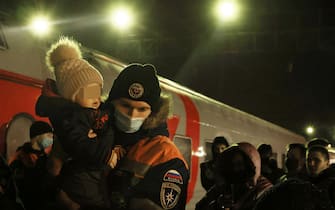 VOLZHSKY, VOLGOGRAD REGION, RUSSIA - FEBRUARY 20, 2022: A Russian Emergencies Ministry employee carries a child at a railway station where a train carrying people evacuated from the Donetsk and Lugansk People's Republics has arrived. Amid the escalating conflict in east Ukraine, on February 18, 2022, the heads of the Lugansk and Donetsk People's Republics announced a mass evacuation of civilians to Russia. The first train carrying 400 evacuated Donbass residents has arrived in the town of Volzhsky from Russia's Rostov-on-Don Region. Dmitry Rogulin/TASS

EDITORIAL USE ONLY. NO COMMERCIAL USE. NO ADVERTISING (Photo by Dmitry Rogulin\TASS via Getty Images)