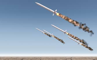 A row of intercontinental ballistic missiles launching in a desert on a blue sky backgrund - 3D render