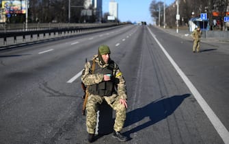 An Ukrainian service member holds a cup of tea as he patrol the empty road on west side of the Ukrainian capital of Kyiv in the morning of February 26, 2022. - Ukrainian soldiers beat back a Russian attack in the capital Kyiv only hours after President Volodymyr Zelensky warns Moscow would attempt to take the city before dawn. (Photo by Daniel LEAL / AFP) (Photo by DANIEL LEAL/AFP via Getty Images)
