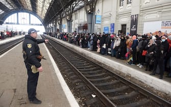 TOPSHOT - People wait for a train to Poland at the railway station of the western Ukrainian city of Lviv on February 26, 2022. - Ukrainian forces repulsed a Russian attack on Kyiv but "sabotage groups" infiltrated the capital, officials said on February 26 as Ukraine reported 198 civilians killed in Russia's invasion so far. A defiant Ukrainian President Volodymyr Zelensky vowed his pro-Western country would never give in to the Kremlin even as Russia said it had fired cruise missiles at military targets. (Photo by Yuriy Dyachyshyn / AFP) (Photo by YURIY DYACHYSHYN/AFP via Getty Images)