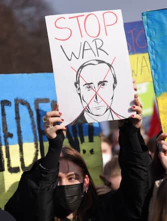 BERLIN, GERMANY - FEBRUARY 27: People, including one participant with a sign cancelling Russian President Vladimir Putin, protest against the ongoing war in Ukraine on February 27, 2022 in Berlin, Germany. Tens of thousands of people rallied in the city center to protest against the war as Ukraine seeks to defend itself in ongoing raging battles against a large-scale Russian military invasion. (Photo by Sean Gallup/Getty Images)