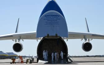 TOPSHOT - Crew members wearing protective equipment prepare to unload medical cargo from China from an Antonov-225 Mriya cargo plane after its arrival at an airfield in Gostomel outside Kiev on April 23, 2020, amid the COVID-19 coronavirus pandemic. (Photo by GENYA SAVILOV / AFP) (Photo by GENYA SAVILOV/AFP via Getty Images)