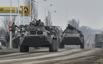 epaselect epa09784378 Russian troops move towards Ukraine on the road near Armiansk, Crimea, 25 February 2022. Russian troops entered Ukraine on 24 February prompting the country's president to declare martial law and triggering a series of announcements by Western countries to impose severe economic sanctions on Russia.  EPA/STRINGER
