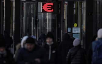 epa09784247 People walk in front of an electronic panel displaying the euro sign at an exchange office in Moscow, Russia, 25 February 2022. The dollar and the euro are confidently rising on the Moscow Exchange, the ruble accelerated its fall against the dual-currency basket in anticipation of the announcement by Western countries of the previously announced new anti-Russian sanctions.  In response to the military operation of the Russian armed forces that began in Ukraine, US authorities imposed sanctions against a number of key Russian banks.  The US sanctions list includes VTB, Sberbank, Gazprombank, Sovcombank, Novikombank, Otkritie Bank, Alfa-Bank and Credit Bank of Moscow.  EPA / MAXIM SHIPENKOV
