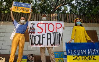 Protesters hold placards during a demonstration against the Russian attack on Ukraine in front of the Russian Embassy in Bangkok. (Photo by Varuth Pongsapipatt / SOPA Images/Sipa USA)