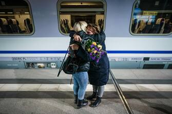 epa09797364 A woman with a flower bouquet resembling the national colors of Ukraine (R) hugs an arriving passenger from a train carrying refugees from the Ukrainian-Polish boarder at Berlin central station Hauptbahnhof in Berlin, Germany, 02 March 2022. Russian troops entered Ukraine on 24 February prompting the country's president to declare martial law and triggering a series of announcements by Western countries to impose severe economic sanctions on Russia. Refugees fleeing Ukraine are brought by trains, among other destinations, to the German capital.  EPA/CLEMENS BILAN