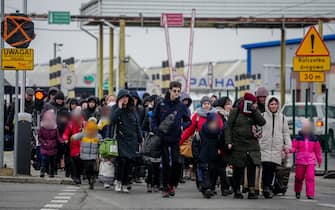 04 March 2022, Poland, Korczowa: Refugees cross the Ukrainian border and head towards Poland at the Korczowa border crossing. Numerous people arrive here every day, fleeing the war in Ukraine. Photo: Kay Nietfeld/dpa (Photo by Kay Nietfeld/picture alliance via Getty Images)