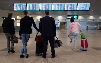 epa09242852 People look at the information board at airport Domodedovo in Moscow, Russia, 02 June 2021. German airline Lufthansa cancelled two flights from Frankfurt to Moscow and back bypass Belarus.  EPA/MAXIM SHIPENKOV