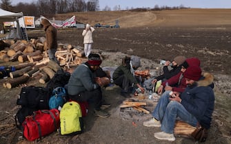 HREBENNE, POLAND - MARCH 01: Indian and Nepalese students who had been studying at Poltava University of Economics and Trade in Ukraine prepare food around a campfire after arriving at the border following an arduous journey on March 01, 2022 near Hrebenne, Poland. The said they plan to continue by bus to Warsaw, where some said they will return to their native countries while others said they will wait, hoping that the current war in Ukraine will be brief and that they can return to Poltava to finish their studies. Governments around the world are still struggling to evacuate their citizens caught between Russia's armed invasion and the mounting humanitarian crisis as Ukrainians flee to neighbouring countries.  (Photo by Sean Gallup/Getty Images)