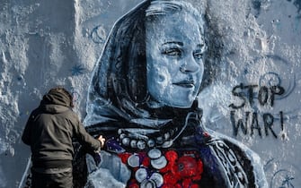 Berlin-based Colombian street artist Arte Vilu works on a mural featuring a Ukrainian woman in traditional dress, in Berlin on February 28, 2022. (Photo by John MACDOUGALL / AFP) (Photo by JOHN MACDOUGALL/AFP via Getty Images)