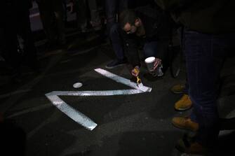 TOPSHOT - A protester paints the "Z" sign on a street, in reference to Russian tanks marked with the letter, during a rally organised by Serbian right-wing organisations in support of Russian invasion in Ukraine, in Belgrade March 4, 2022. - Around a thousand Serbian ultra nationalist supporters marched in Belgrade in support of the Russian invasion of Ukraine. (Photo by Andrej ISAKOVIC / AFP) (Photo by ANDREJ ISAKOVIC/AFP via Getty Images)