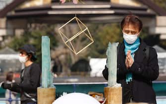 Una persona prega durante la commemorazione della catastrofe di Fukushima