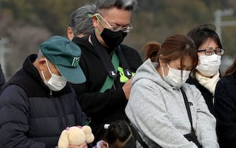 People in silence during the commemoration of the Fukushima catastrophe