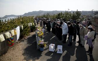 Persone pregano durante la commemorazione della catastrofe di Fukushima