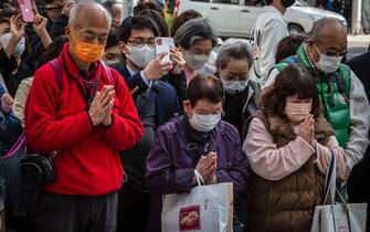 People pray during the commemoration of the Fukushima catastrophe