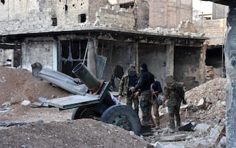 Syrian pro-government forces walk amidst heavy destruction in Aleppo's Bustan al-Basha neighborhood on November 28, 2016, during their assault to retake the entire northern city from rebel fighters.  In a major breakthrough in the push to retake the whole city, regime forces captured six rebel-held districts of eastern Aleppo over the weekend, including Masaken Hanano, the biggest of those in eastern Aleppo.  / AFP / GEORGE OURFALIAN (Photo credit should read GEORGE OURFALIAN / AFP via Getty Images)