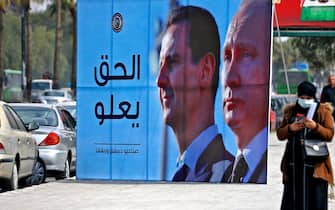 TOPSHOT - A banner depicting Syrian President Bashar al-Assad and Russian President Vladimir Putin and reading "Justice Prevails", is displayed along a highway in the Syrian capital Damascus, on March 8, 2022. (Photo by LOUAI BESHARA / AFP) (Photo by LOUAI BESHARA/AFP via Getty Images)
