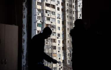 KYIV, UKRAINE - MARCH 17: Damaged windows are seen at an apartment block as men fix a blown out window at a nearby school that was damaged after being hit by the debris of an intercepted Russian rocket in the early hours of the morning on March 17, 2022 in Kyiv, Ukraine. Russian forces remain on the outskirts of the Ukrainian capital, but their advance has stalled in recent days, even while Russian strikes - and pieces of intercepted missiles - have hit residential areas in the north of Kyiv. An estimated half of Kyiv's population has fled to other parts of the country, or abroad, since Russia invaded on February 24. (Photo by Chris McGrath/Getty Images)