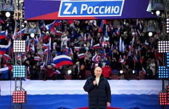 Russian President Vladimir Putin gives a speech during a concert marking the eighth anniversary of Russia's annexation of Crimea at the Luzhniki stadium in Moscow on March 18, 2022. - The banner reads "For Russia". (Photo by Alexander VILF / POOL / AFP) (Photo by ALEXANDER VILF/POOL/AFP via Getty Images)