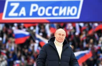 Russian President Vladimir Putin attends a concert marking the eighth anniversary of Russia's annexation of Crimea at the Luzhniki stadium in Moscow on March 18, 2022. - The banner reads 
