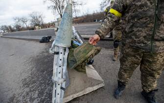 MYKOLAIV, UKRAINE - MARCH 10:  A Ukrainian soldier shows a captured Russian flak vest and casing of a cluster bomb rocket as Ukraine Army troops dig in at frontline trench positions to continue repelling Russian attacks, east of the strategic port city of Mykolaiv, Ukraine, on March 10, 2022. Ukrainian forces have fended off several concerted ground attacks, with Russian forces coming northwest from Crimea and via Kherson, and filing frequent missile and rockets strikes on the city, Ukrainian officers and officials say they are optimistic that they can continue to stop the Russian southern advance along the Black Sea coast. (Photo by Scott Peterson/Getty Images)