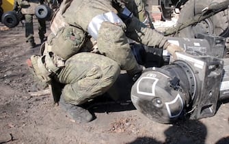 KIEV REGION, UKRAINE - MARCH 15, 2022: A serviceman is seen by military equipment captured by Russian troops. Ten Javelin American-made portable anti-tank missile systems, grenade launchers, man-portable air-defense systems were discovered at a base that was taken under control of the Russian Armed Forces near the village of Huta-Mezhyhirska. Video grab. Best quality available. Russian Defense Ministry/TASS/Sipa USA