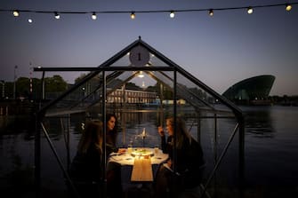 TOPSHOT - A group of friend have dinner in a so-called quarantine greenhouses in Amsterdam, on May 5, 2020 as the country fights against the spread of the COVID-19, the novel coronavirus. (Photo by Robin VAN LONKHUIJSEN / ANP / AFP) / Netherlands OUT (Photo by ROBIN VAN LONKHUIJSEN/ANP/AFP via Getty Images)