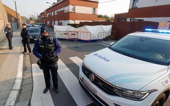 epa09837496 Police officers stand guard in Strepy Bracquegnies, Belgium, 20 March 2022. Four people lost their lives in the morning, when a car ploughed into a carnival group during the pickup of the carnival gilles.  EPA/JULIEN WARNAND