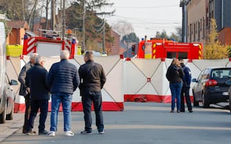 epa09837500 People look at the cordoned off scene in Strepy Bracquegnies, Belgium, 20 March 2022. Four people lost their lives in the morning, when a car ploughed into a carnival group during the pickup of the carnival gilles.  EPA/JULIEN WARNAND