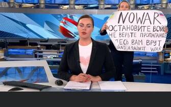 This video grab taken on March 15, 2022 shows Russian Channel One editor Marina Ovsyannikova holds a poster reading " Stop the war. Don't believe the propaganda. Here they are lying to you" during on-air TV studio by news anchor Yekaterina Andreyeva , Russia's most-watched evening news broadcast, in Moscow on March 14, 2022 . As a news anchor Yekaterina Andreyeva launched into an item about relations with Belarus, Marina Ovsyannikova, who wore a dark formal suit, burst into view, holding up a hand-written poster saying "No War" in English. Photo by Stella Pictures/ABACAPRESS.COM