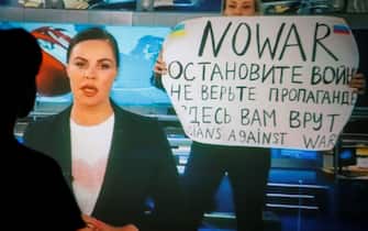 epaselect epa09826233 A woman watches a recorded feed of the Russian Channel One's evening news broadcast TV show in which an employee enters Ostankino on-air TV studio with a poster reading ''No War. Stop the war. Don't believe the propaganda. You are being lied to here" in Moscow, Russia, 15 March 2022. The on-air protest was staged on 14 March by Marina Ovsyannikova, who worked as an editor. She was taken to the Ostankino police department. A protocol was drawn up against an employee of Channel One under the article on military censorship for discrediting the Russian armed forces. On 24 February Russian troops had entered Ukrainian territory in what the Russian president declared a 'special military operation', resulting in fighting and destruction in the country, a huge flow of refugees, and multiple sanctions against Russia.  EPA/DSK