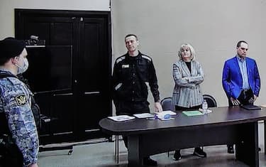 epa09841676 Russian opposition leader and activist Alexei Navalny (C) and his lawyer Olga Mikhailova (2-R) are seen on a monitor screen during an offsite court session in the penal colony N2 (IK-2) in Pokrov, Vladimir region, Russia, 22 March 2022. The Lefortovo Court of Moscow, at an offsite hearing in correctional colony 2, on March 22 announced the verdict against Russian opposition leader Alexei Navalny in the case of fraud and insulting the court. The founder of the Anti-Corruption Foundation, Alexei Navalny, was poisoned in the summer of 2020 and taken to Berlin for treatment, from where he flew to Moscow in January 2021. Immediately upon his return to Russia, he was detained and arrested. Since March 2021, he has been in a colony in the city of Pokrov, Vladimir Region.  EPA/YURI KOCHETKOV