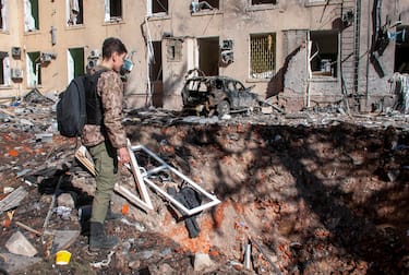 epa09842711 A man looks at a hole after shelling in the Eastern-Ukrainian city of Kharkiv, Ukraine, 22 March 2022. The city of Kharkiv, Ukraine's second-largest, has witnessed repeated airstrikes from Russian force. Russian troops entered Ukraine on 24 February resulting in fighting and destruction in the country, and triggering a series of severe economic sanctions on Russia by Western countries.  EPA/VASILIY ZHLOBSKY