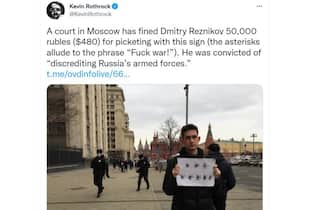Un manifestante russo contro la guerra in Ucraina con in mano un cartello con asterischi