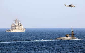 Handout photo dated December 21, 2020 of The MH-60R Seahawk helicopter, attached to the Helicopter Sea Maritime (HSM 48) Squadron, flies above the guided-missile submarine USS Georgia (SSGN 729) as the submarine transits with the Ticonderoga-class guided-missile cruiser USS Port Royal (CG 73) on the Strait of HormuzThe US Navy appears to be sending a message to Iran in the form of a guided-missile submarine equipped with tremendous firepower and possibly special operations troops. The Ohio-class guided-missile submarine USS Georgia sailed into the Persian Gulf on Monday. For the first time in eight years, the Navy announced the presence of a guided-missile submarine in the Persian Gulf. U.S. Navy photo by Mass Communication Specialist 2nd Class Indra Beaufort via ABACAPRESS.COM