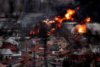 Dark smoke and flames rise from a fire following an air strike in the western Ukrainian city of Lviv, on March 26, 2022. - At least five people wounded in two strikes on Lviv, the regional governor said, in a rare attack on a city that has escaped serious fighting since Russian troops invaded last month. (Photo by Ronaldo SCHEMIDT and RONALDO SCHEMIDT / AFP)