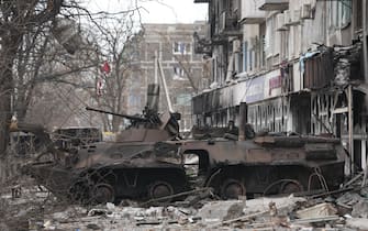 MARIUPOL, UKRAINE - MARCH 26: A wrecked tank is seen near a damaged building as civilians are being evacuated along humanitarian corridors from the Ukrainian city of Mariupol under the control of Russian military and pro-Russian separatists, on March 26, 2022. (Photo by Stringer/Anadolu Agency via Getty Images)