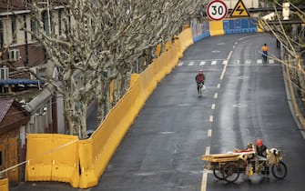 A cyclist rides past a perimeter wall of a neighborhood placed under lockdown due to Covid-19 in Shanghai, China, on Saturday, March 26, 2022. China’s economy faces its worst downward pressure since the spring of 2020 when it was hit by the first wave of Covid-19, according to Nomura Holdings Inc. Photographer: Qilai Shen/Bloomberg
