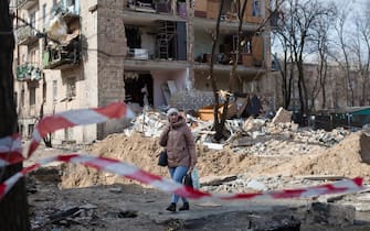 KYIV, UKRAINE - MARCH 28: A woman walks through the residential area which was destroyed as a result of a rocket strike two weeks ago on March 28, 2022 in Kyiv, Ukraine. Ukraine's military says it has made territorial gains in the wider Kyiv region, after Russia's advance on the capital had largely stalled in recent weeks. But intermittent shelling and missile strikes persist. (Photo by Anastasia Vlasova/Getty Images)