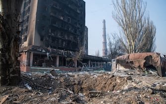 MARIUPOL, UKRAINE - 2022/03/23: A destroyed apartment building and a large crater caused by an airstrike seen in the city centre. The battle between Russian / Pro Russian forces and the defencing Ukrainian forces lead by Azov battalion continues in the port city of Mariupol. (Photo by Maximilian Clarke/SOPA Images/LightRocket via Getty Images)