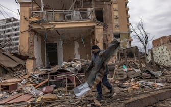 epa09856739 A volunteer cleans rubble from the area next to destroyed buildings that were shelled by Russian forces, in Kharkiv, northeast Ukraine, 28 March 2022. Kharkiv, Ukraine s second-largest city of 1.5 million people, which lies about 25 miles from the Russian border, has been heavily shelled by Russian forces over the past weeks, with many civilians killed in the city.  EPA/ROMAN PILIPEY
