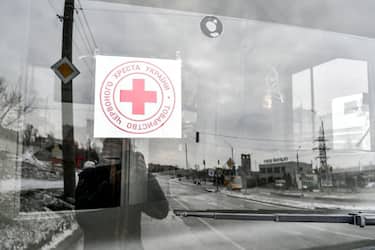 A sticker of the Ukrainian Red Cross Society is attached to the windscreen of one of the buses set to take off for besieged Mariupol to deliver humanitarian aid and evacuate people should the green corridor be confirmed, Zaporizhzhia, southeastern Ukraine. on March 6, 2022.  (Photo by Dmytro Smolyenko/Ukrinform/NurPhoto via Getty Images)