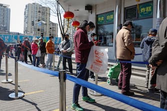 epa09863092 People lineup to buy food at a store in Beijing, China, 01 April 2022. China's use of lockdowns to contain the coronavirus and COVID-19 pandemic around the country will take a toll on the economy, analysts stated. The country's target growth rate of 5.5 percent could lose ten percentage points on a quarterly basis if it sticks to it's zero-COVID-19 strategy, according to a statement from Everbright Securities.  EPA/MARK R. CRISTINO