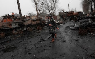 epaselect epa09868080 A Ukrainian woman walks past destroyed Russian military machinery in the city of Bucha, Ukraine, 03 April 2022, one of the areas recaptured by the Ukrainian army from Russian forces. On 24 February, Russian troops had entered Ukrainian territory in what the Russian president declared a 'special military operation', resulting in fighting and destruction in the country, a huge flow of refugees, and multiple sanctions against Russia  EPA/ATEF SAFADI