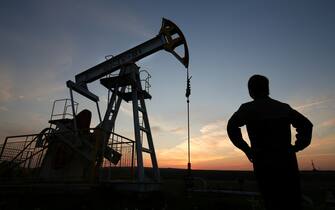 482903294 The sun sets beyond an oil pumping unit, also known as a "nodding donkey" or pumping jack, at a drilling site operated by Tatneft OAO near Almetyevsk, Russia, on Friday, July 31, 2015. Eleven months of surviving with oil below $100 have left Russia hardened enough to endure a monthlong drop to $40 a barrel, a survey of economists showed. Photographer: Andrey Rudakov/Bloomberg via Getty Images