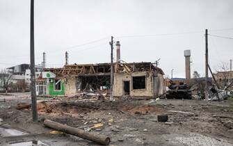 1239703728 BUCHA, UKRAINE - 2022/04/02: A crater from an exploding shell, a destroyed building and a burnt tank seen on a highway in Bucha, Kyiv region. Almost 300 civilians have been killed along the road in Bucha, a commuter town outside capital Kyiv as most victims tried to cross the Buchanka river to reach the Ukrainian controlled territory and had been killed. Russia invaded Ukraine on 24 February 2022, triggering the largest military attack in Europe since World War II. (Photo by Mykhaylo Palinchak/SOPA Images/LightRocket via Getty Images)