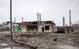 BUCHA, UKRAINE - 2022/04/02: A crater from an exploding shell, a destroyed building and a burnt tank seen on a highway in Bucha, Kyiv region. Almost 300 civilians have been killed along the road in Bucha, a commuter town outside capital Kyiv as most victims tried to cross the Buchanka river to reach the Ukrainian controlled territory and had been killed. Russia invaded Ukraine on 24 February 2022, triggering the largest military attack in Europe since World War II. (Photo by Mykhaylo Palinchak/SOPA Images/LightRocket via Getty Images)